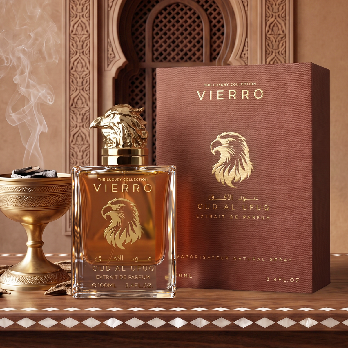 OUD AL UFUQ Extrait de Parfum by Vierro featuring a 100ml bottle with a gold falcon head cap alongside its matching product box on an ornate wooden surface with an incense burner in the background.