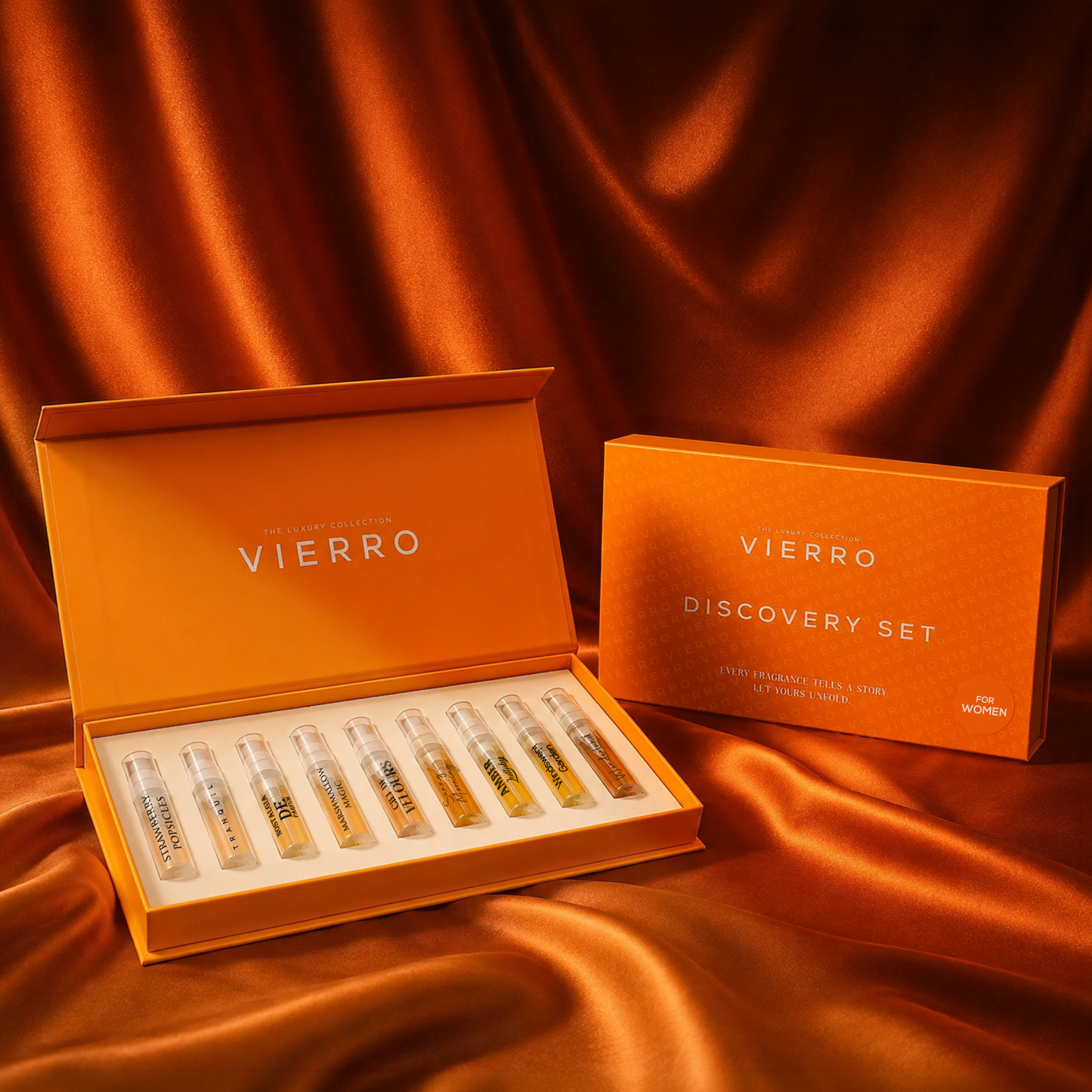 Vierro Discovery Set women perfume sample vials presented in an orange box next to its matching outer packaging, set against a draped orange satin fabric background.
