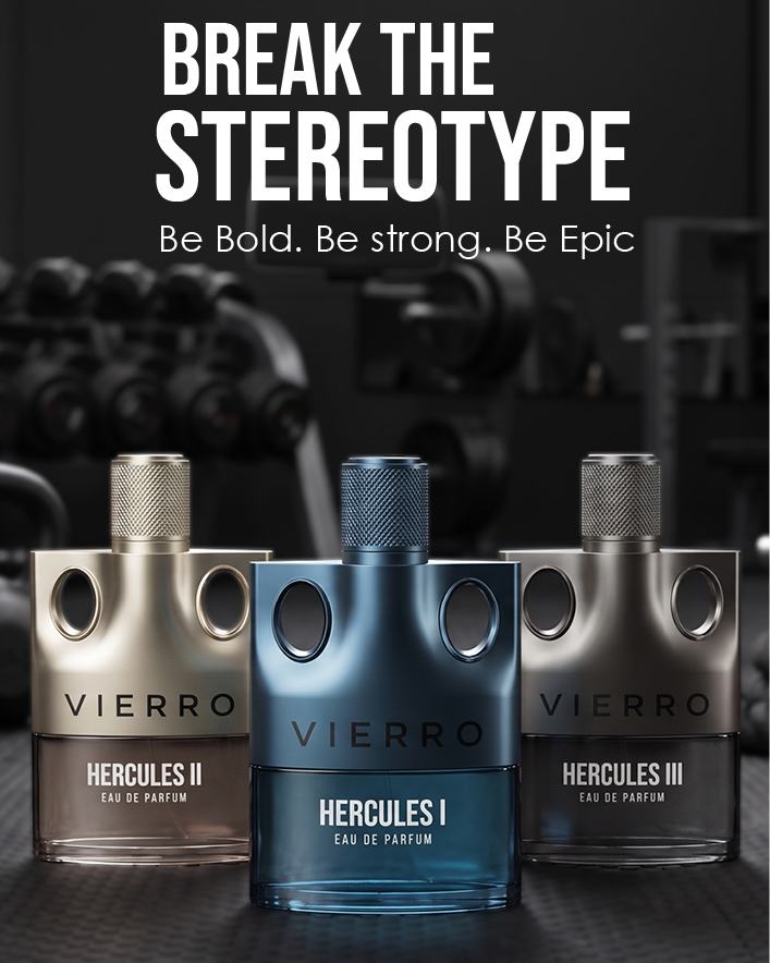 Three VIERRO Hercules fragrance bottles are displayed on a dark textured surface with a blurred gym background. The center bottle is metallic blue and labeled HERCULES I, flanked by metallic silver bottles labeled HERCULES II on the left and HERCULES III on the right.