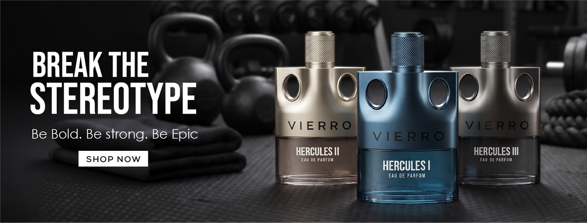 Three VIERRO fragrance bottles displayed against a dark gym background with dumbbells. The center bottle is blue and labeled HERCULES I, flanked by gold-toned HERCULES II on the left and dark gray HERCULES III on the right.